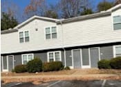 Thumbnail 2 of 7 - A building with grey siding and white trim.