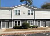 Thumbnail 7 of 7 - A small building with a grey siding and a white roof.