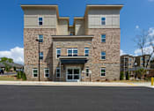 Thumbnail 2 of 38 - A large stone building with a flat roof and a garage door in the front.
