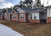 Thumbnail 1 of 8 - A row of houses with a white fence in front.