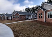 Thumbnail 4 of 8 - A row of houses with a sidewalk in front.
