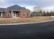 Thumbnail 3 of 8 - A house with a brick facade and a covered porch.