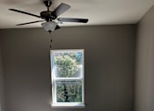 Thumbnail 3 of 8 - A room with a ceiling fan and a window.