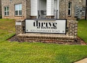 Thumbnail 10 of 10 - A sign for Thrive at South End is in front of a brick building.