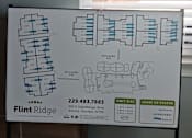 Thumbnail 6 of 14 - A sign for Flint Ridge Apartments shows the layout of the buildings and the lease up status.