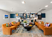 Thumbnail 6 of 13 - A room with a round table and orange chairs.