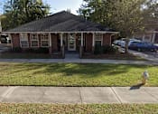 Thumbnail 4 of 16 - A small brick house with a porch and a fire hydrant in front.