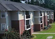 Thumbnail 3 of 16 - A row of apartment buildings with red brick pillars.