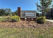 Thumbnail 1 of 6 - A sign for a Wood Elberton office is in front of a brick chimney.