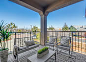 Thumbnail 41 of 53 - A balcony with a bench, cushions, and a potted plant.