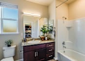 Thumbnail 49 of 53 - A bathroom with a white tub, sink, and toilet.