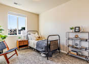 Thumbnail 27 of 53 - A bedroom with a bed, chair, and shelf.