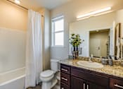 Thumbnail 32 of 53 - A white toilet sits in a bathroom with a white shower curtain.