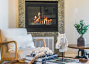 Thumbnail 22 of 53 - A living room with a fireplace and a chair.