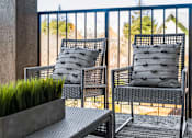 Thumbnail 15 of 53 - Two chairs and a table on a balcony.