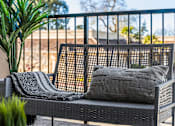 Thumbnail 21 of 53 - A black metal patio set with a grey cushion and a grey throw on it.