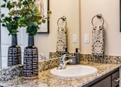Thumbnail 17 of 53 - A bathroom with a sink, mirror, and towel racks.