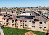 Thumbnail 1 of 53 - A large building with a lot of windows and a green lawn in front.