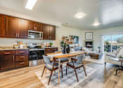 Thumbnail 39 of 53 - A modern kitchen with a dining table and chairs.
