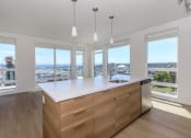 Thumbnail 23 of 24 - a kitchen with a large center island with a white countertop at Napoleon Apartments, Tacoma, WA