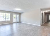Thumbnail 11 of 14 - A spacious room with wood flooring and a large window at Ballantyne Commons of Stockbridge Apartments, Georgia, 30281