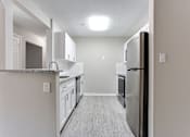 Thumbnail 8 of 14 - A kitchen with a refrigerator, cabinets, and a counter at Ballantyne Commons of Stockbridge Apartments, Georgia, 30281
