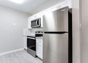 Thumbnail 7 of 14 - A kitchen with a stainless steel refrigerator, microwave, oven, and dishwasher at Ballantyne Commons of Stockbridge Apartments, Georgia