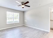 Thumbnail 13 of 14 - A room with a ceiling fan and a window at Ballantyne Commons of Stockbridge Apartments, Stockbridge, GA