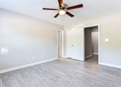 Thumbnail 12 of 14 - A room with a ceiling fan and light fixture, two doors, and a wall-mounted light switch at Ballantyne Commons of Stockbridge Apartments, Stockbridge, Georgia