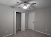 Thumbnail 11 of 20 - A room with a ceiling fan and two doors at The Madison Apartments and Townhomes, Lawrenceville, GA
