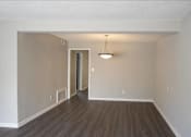 Thumbnail 20 of 20 - A room with a wooden floor and a light hanging from the ceiling at The Madison Apartments and Townhomes, Georgia 30044