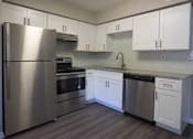 Thumbnail 5 of 20 - A kitchen with a stainless steel refrigerator, oven, and dishwasher at The Madison Apartments and Townhomes, Lawrenceville