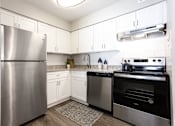 Thumbnail 1 of 27 - A modern kitchen with a stainless steel refrigerator and oven at Barcelo at East Cobb Apartments, Georgia