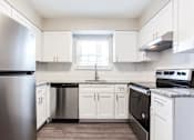 Thumbnail 3 of 27 - A kitchen with white cabinets and a stainless steel refrigerator at Barcelo at East Cobb Apartments, GA, 30067
