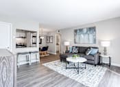 Thumbnail 4 of 27 - A living room with a grey couch, a white coffee table, and a painting on the wall at Barcelo at East Cobb Apartments, Marietta