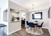 Thumbnail 7 of 27 - A kitchen with a bar stool and a dining table with chairs at Barcelo at East Cobb Apartments, Georgia