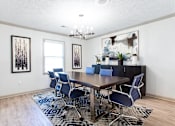 Thumbnail 17 of 27 - A dining room with a wooden table and blue chairs at Barcelo at East Cobb Apartments, Georgia, 30067