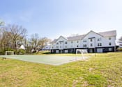 Thumbnail 18 of 27 - A tennis court is located in front of a white building at Barcelo at East Cobb Apartments, Georgia