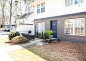 Thumbnail 24 of 27 - A house with a blue door and a white van parked in front at Barcelo at East Cobb Apartments, GA, 30067