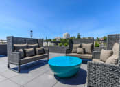 Thumbnail 14 of 24 - a seating area with couches and a coffee table on a rooftop patio at Napoleon Apartments, Washington, 98402 