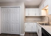 Thumbnail 11 of 60 - a white kitchen with white cabinets and a sink at Cleo Apartments, Alabama, 35611