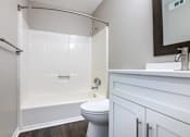 Thumbnail 16 of 60 - a white bathroom with a shower and a toilet at Cleo Apartments, Athens, AL