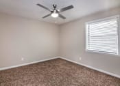 Thumbnail 22 of 60 - an empty bedroom with a ceiling fan and a window at Cleo Apartments, Athens, 35611