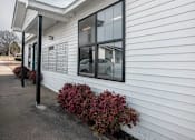 Thumbnail 30 of 60 - the side of a white building with windows and a sidewalk at Cleo Apartments, Athens, AL