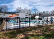 Thumbnail 39 of 60 - a pool with a fence in front of a house at Cleo Apartments, Athens, AL