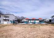 Thumbnail 44 of 60 - a yard with a fenced in pool and some houses at Cleo Apartments, Athens, Alabama