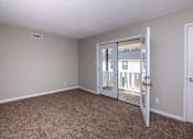 Thumbnail 57 of 60 - an empty living room with a door to a balcony at Cleo Apartments, Athens, AL