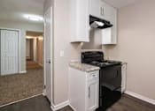 Thumbnail 8 of 60 - a kitchen with white cabinets and a black stove at Cleo Apartments, Athens, 35611