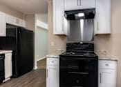Thumbnail 9 of 60 - a kitchen with black appliances and white cabinets at Cleo Apartments, Alabama, 35611