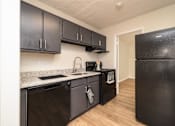 Thumbnail 1 of 14 - A kitchen with black cabinets and appliances at Overlook Club Apartments, Cummings, 30040